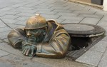 Bronze figure of a Sewer worker peeks through the manhole in Bratislava